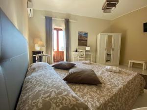 a bedroom with a bed with two pillows on it at Il filo di Arianna, ad un passo da tutto in Syracuse