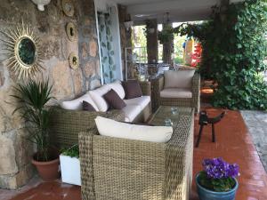 patio z wiklinowymi krzesłami, kanapą i stołem w obiekcie Casa Rural en Las Nieves w mieście Las Nieves