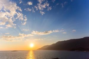 a sunset over a body of water with a mountain at Medimar Hotel in Kaş