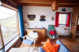 - un salon avec un canapé, des chaises et un bureau dans l'établissement Idyllic Vacation Home with a Breathtaking View, à Bøur