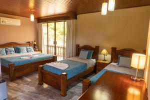 a bedroom with two beds and a table at Hotel Margarita and Tour Operator Drake Bay in Drake