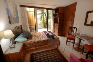een slaapkamer met een bed, een tafel en een raam bij Majikal B&B - Ganesha in Cholula