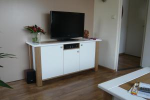 a tv on top of a white cabinet in a room at Welca in Baarlo