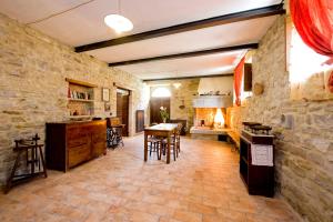 een keuken met een stenen muur en een tafel en stoelen bij Borgo Di Cortolla in Pietralunga