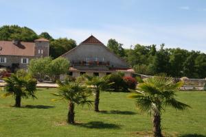 una casa con palmeras delante en Manoir Théas en Barraute-Camu