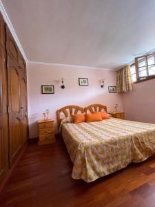 sypialnia z dużym łóżkiem z pomarańczowymi poduszkami w obiekcie Apartamento Neptuno playa 17 w mieście Puerto de Santiago