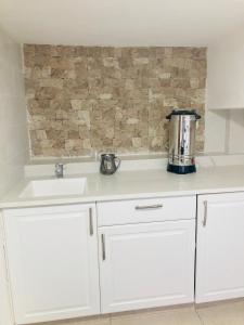 a kitchen with white cabinets and a sink at צימר בצפת, מרווח ושקט, חצר גדולה, מיועד לשומרי שבת, ישנן שתי מיטות רגילות ועוד שתיים מתקפלות, ארבע מיטות סך הכל in Safed +4 photos