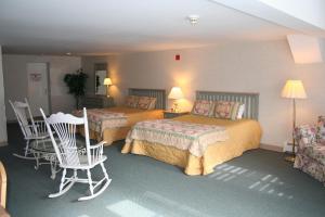 庫珀斯敦的住宿－願景賓館，酒店客房带两张床和一张桌子以及椅子。