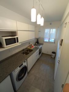 a kitchen with a sink and a washing machine at Mi Lugar en Rosario - Depto céntrico VIP, 3 amb con cochera opcional in Rosario