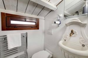 Un baño blanco con inodoro y lavabo. en Venice traditional home with terrace, en Venecia