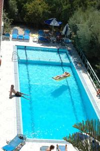 ヘルソニソスにあるNontas Apartmentsの青い大きなプールで泳ぐ女