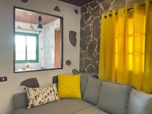 a living room with a couch with yellow curtains at Casa Arrantzale II in El Cercado