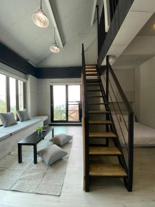 een woonkamer met een trap en een bank bij Evi Bnb in Fanlu