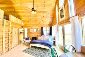 een slaapkamer met een bed en een plafondventilator bij Harvest Moon Loft in Sylva