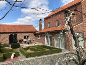 a brick house with a garden in front of it at Hoeve de Singel in Borgloon