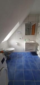 La salle de bains est pourvue de carrelage bleu, d'un lavabo et de toilettes. dans l'établissement Gästehaus Burgberg, Weinhaus Fries, à Kattenes 73 autres photos
