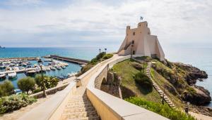 a lighthouse on a hill next to the ocean at Casa Noemi in Sperlonga