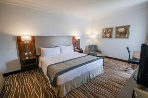 a hotel room with a bed and a television at Copthorne Downtown by Millennium in Abu Dhabi