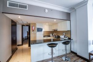 a kitchen with a counter and two bar stools at Copthorne Downtown by Millennium in Abu Dhabi