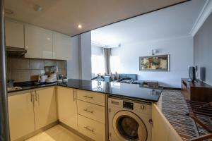 a kitchen with a sink and a washing machine at Copthorne Downtown by Millennium in Abu Dhabi