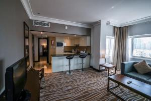 a living room with a couch and a tv at Copthorne Downtown by Millennium in Abu Dhabi