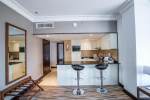 a kitchen with a counter and two bar stools at Copthorne Downtown by Millennium in Abu Dhabi
