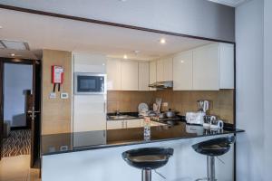 a kitchen with a counter with two stools at Copthorne Downtown by Millennium in Abu Dhabi