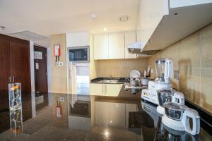a kitchen with a sink and a stove in it at Copthorne Downtown by Millennium in Abu Dhabi