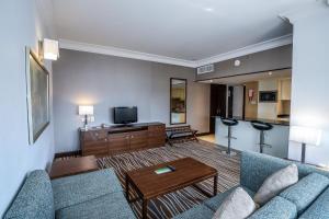 a living room with a couch and a tv at Copthorne Downtown by Millennium in Abu Dhabi