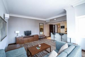 a living room with a couch and a tv at Copthorne Downtown by Millennium in Abu Dhabi