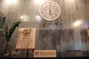 北革โรงแรมดับเบิ้ลดี ปากเกร็ด Double D hotel的挂在墙上的时钟,有标志