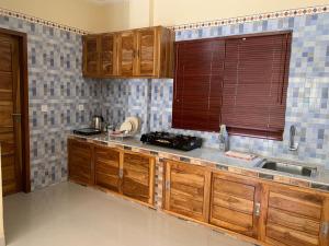 cocina con armarios de madera, fregadero y ventana en Diver's Cafe Amed, en Amed
