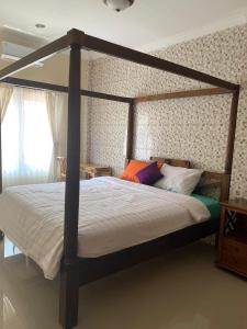 1 dormitorio con 1 cama grande con marco de madera en Diver's Cafe Amed, en Amed