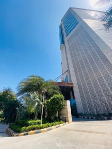 a building with a palm tree in front of it at Seven Seas Hotel in New Delhi