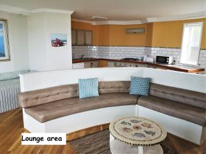 uma sala de estar com um sofá e uma cozinha em Omega apartment em Jeffreys Bay