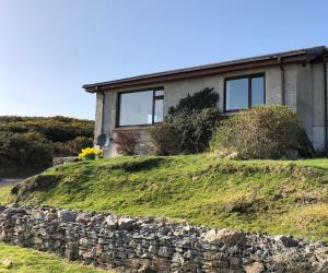 a house on a hill with a stone wall at The Stroops in Helmsdale