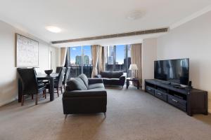 a living room with a couch and a flat screen tv at Jade Resorts Melbourne in Melbourne