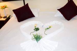 un lit en forme de cœur avec une composition florale dans l'établissement Hotel Le Paris, à Nouméa