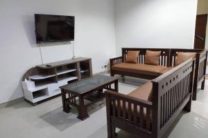 a living room with wooden furniture and a flat screen tv at Awana Dream 4 bedrooms house , 5min to Alun Alun, Kraton, Malioboro bdc in Yogyakarta