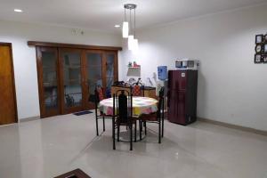 a kitchen with a table with chairs and a refrigerator at Awana Dream 4 bedrooms house , 5min to Alun Alun, Kraton, Malioboro bdc in Yogyakarta
