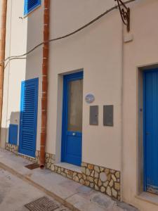 a blue and white building with a blue door at Scalovecchio in Marettimo