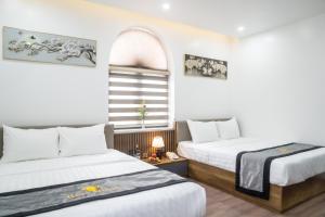 Un pat sau paturi într-o cameră la Rose Hotel Quảng Bình