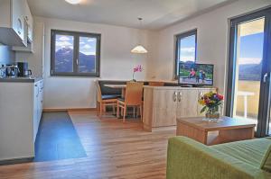 a living room with a kitchen and a dining room at Residence Vellauerhof in Lagundo