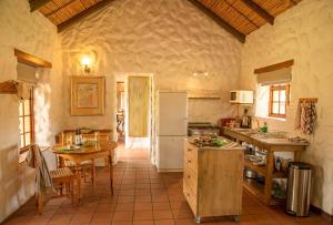 a large kitchen with a refrigerator and a table at Mount Ceder in De Straat
