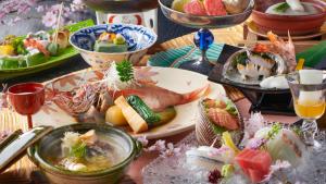 una mesa cubierta con platos de comida y bebida en Mansuirou, en Misasa