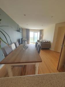 a dining table and chairs in a living room at Harbour Beach Apartment in Pevensey