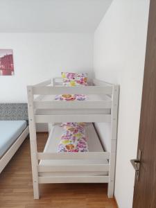 a white bunk bed in a white room with a pillow at Venice Apartment in Interlaken