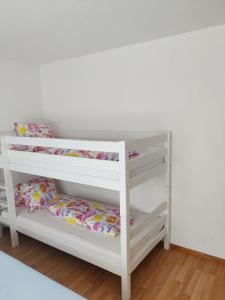 two bunk beds in a room with white walls at Venice Apartment in Interlaken