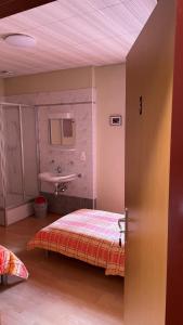 1 dormitorio con 1 cama y lavamanos. en Ristorante Dosso, en Sigirino