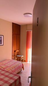 a bedroom with a bed and a table and a window at Ristorante Dosso in Sigirino